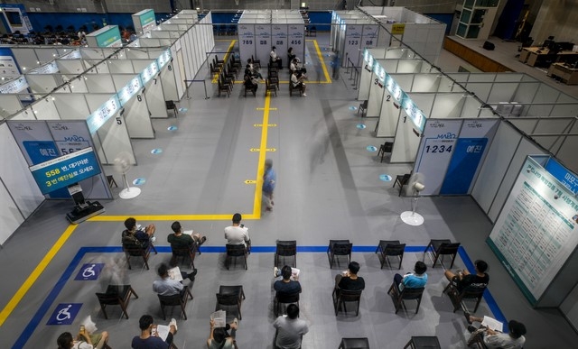 지난 20일 오후 서울 마포구 마포구체육센터에 설치된 예방접종센터를 찾은 시민들이 백신 접종을 받기 위해 대기하고 있다.