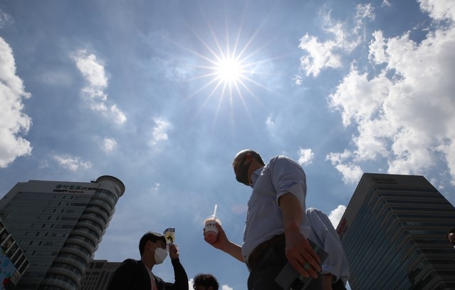 중복인 지난 21일 오후 서울 종로구 세종로 네거리에서 시민들이 뜨거운 햇살 아래 발걸음을 재촉하고 있다.