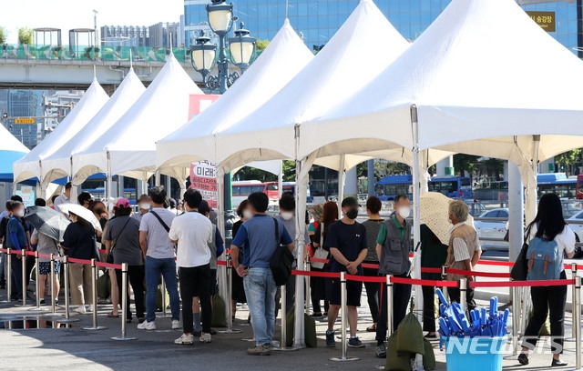 코로나19 신규 확진자 수가 지난 7일부터 연일 1,000명 이상 집계된 26일 오전 서울 중구 서울역광장에 설치된 코로나19 임시선별검사소에서 시민들이 검사를 받기 위해 대기하고 있다.