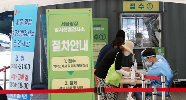 신규 코로나19 확진자 수가 1,318명으로 집계된 26일 오전 서울 중구 서울광장 임시선별검사소에서 시민들이 검사를 받기 위해 접수하고 있다.