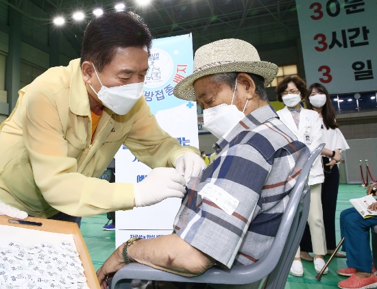 구충곤 화순군수가 지난 13일 화순군 코로나19 예방접종센터를 찾아 백신 접종을 마친 65세 이상 어르신들에게 ‘백신 접종 배지’를 달아주고 있다./사진=화순군