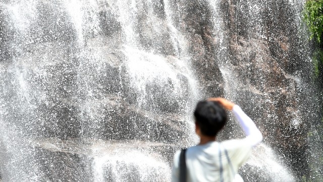 낮 기온이 35도를 넘나드는 폭염이 지속되는 지난 27일 오후 서울 중랑구 용마폭포공원을 찾은 시민들이 폭포 앞에서 더위를 식히고 있다.