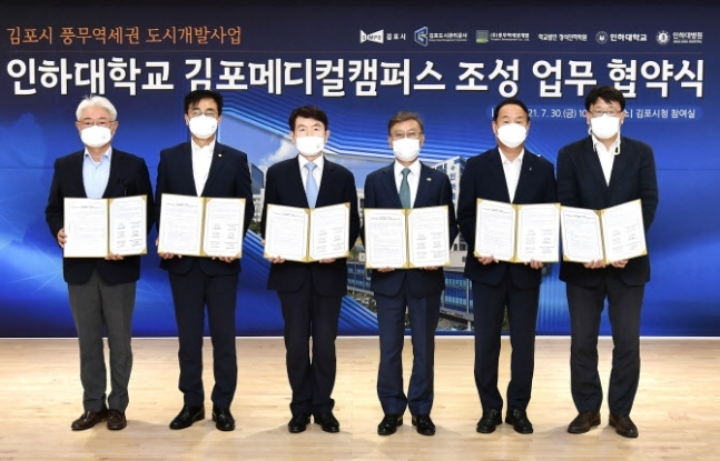 경기 김포 풍무역세권개발 대학 용지에 인하대학교 김포메디컬캠퍼스와 최첨단 대학병원이 조성된다.정하영(왼쪽서 4번째) 김포시장이 30일 시청 참여실에서 현정택 정석인하학원 이사장, 조명우 인하대 총장, 김영모 인하대병원장 등과 인하대 김포메디컬캠퍼스 조성을 위한 업무협약을 한 뒤 기념 촬영하고 있다. (사진=김포시 제공)