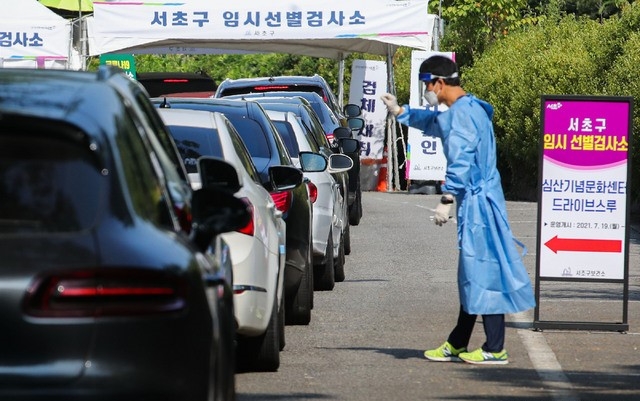코로나19 신규 확진자가 1710명을 기록한 30일 오전 서울 서초구 심산기념문화센터 드라이브스루 임시선별검사소를 찾은 시민들의 차량이 검사를 받기 위해 길게 줄지어 대기하고 있다.