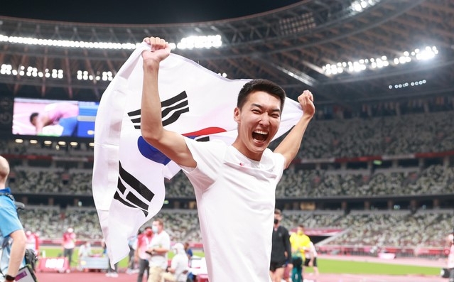 육상 국가대표 우상혁이 1일 오후 도쿄 올림픽스타디움에서 열린 2020 도쿄올림픽 남자 높이뛰기 결승전 경기에서 4위 2.35 한국신기록을 달성한 뒤 태극기를 들어보이고 있다.