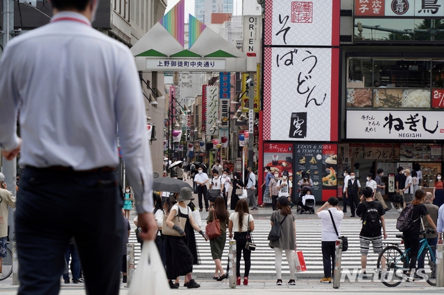 일본 수도 도쿄의 우에노역 부근에 있는 횡단보도에서 지난달 30일  코로나19 예방을 위해 마스크를 착용한 시민들이 신호등이 바뀌기를 기다리고 있다.