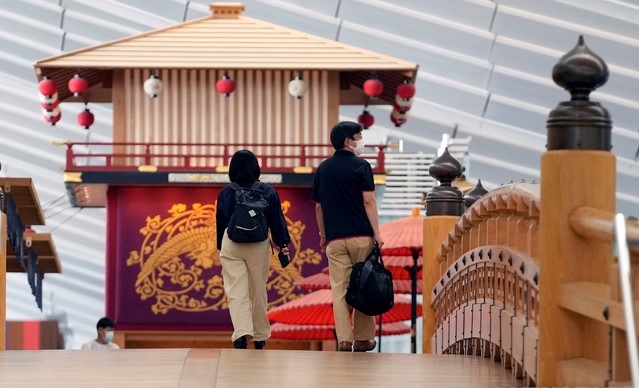 일본 수도 도쿄에 있는 하네다 공항을 2일 찾은 시민들이 코로나19 예방을 위해 마스크를 쓴 채 여객기 탑승에 앞서 전통식으로 지은 다리를 건너고 있다.