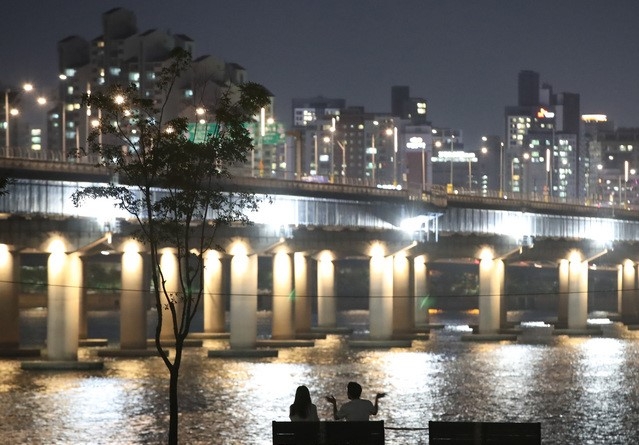 폭염 속 열대야가 몇주째 지속되고 있는 4일 오후 서울 영등포구 여의도 한강공원에서 시민들이 강바람을 맞으며 더위를 식히고 있다.
