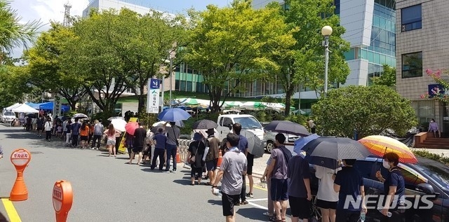 지난 5일 오후 경남 창원보건소 선별진료소에서 코로나19 진단검사를 받으려는 시민들이 찜통더위 속에 줄지어 기다리고 있다.