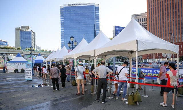 지난 7일 오전 서울 중구 서울역광장에 설치된 코로나19 임시선별검사소를 찾은 시민들이 검사를 받기 위해 줄 서 있다.