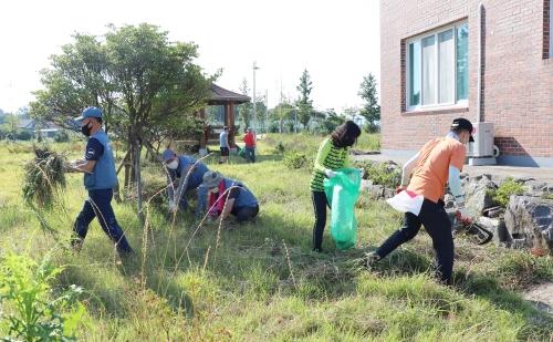 단원들과 직원 가족들이 쓰레기 줍기, 분리수거 등 길가를 정리하고 있다/사진=광양제철소