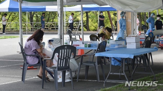 대구지역 코로나19 확진자가 86명으로 집계된 9일 오전 대구 수성구 대구스타디움 주차장에 마련된 임시선별검사소에서 의료진이 검체 채취를 하고 있다.