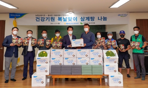 손병환 NH농협금융지주 회장(사진 왼쪽에서 다섯 번째), 신만철 좌운1리 이장(사진 왼쪽에서 여섯 번째)과 관계자들이 삼계탕 꾸러미 전달 후 기념촬영을 하고 있다./ 사진 제공 = NH농협금융지주