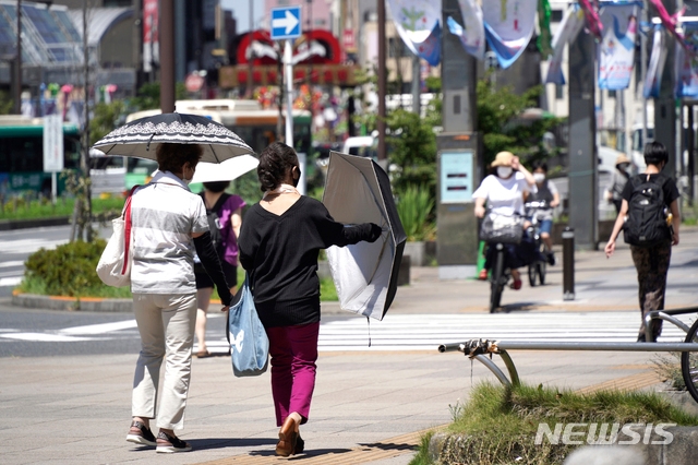 5일 일본 도쿄에서 코로나19 확산을 막기 위해 마스크를 쓴 사람들이 거리를 걷고 있다
