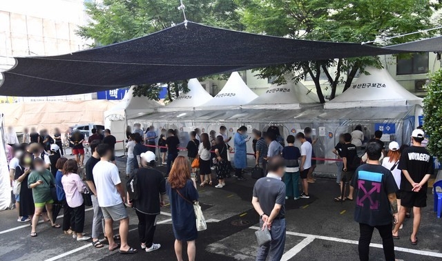 부산지역 코로나19 확진자가 속출하고 있는 9일 오후 부산진구 보건소 선별진료소를 찾은 시민들이 진단검사를 받기 위해 길게 줄을 선 채 차례를 기다리고 있다.