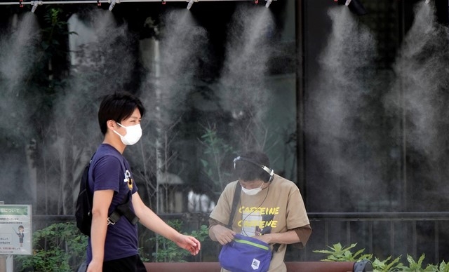 10일 일본 도쿄에 설치된 무더위를 식히는 쿨링존에서 코로나19 확산 방지를 위해 마스크를 쓴 남성들이 더위를 식히고 있다. 일본 기상청은 수도권 지역 기온이 38도까지 오르면서 무더운 날씨가 이어지고 있다고 밝혔다.