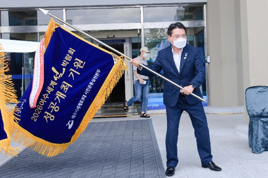 권오봉 여수시장이 11일 본청 현관 앞에서 2026여수세계섬박람회 성공개최 기원기를 흔들고 있다./사진=여수시