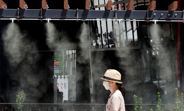 10일 일본 도쿄에서 코로나19 확산 방지를 위해 마스크를 쓴 한 여성이 무더위를 식히는 쿨링존을 지나가고 있다. 일본 기상청은 수도권 지역 기온이 38도까지 오르면서 무더운 날씨가 이어지고 있다고 밝혔다.