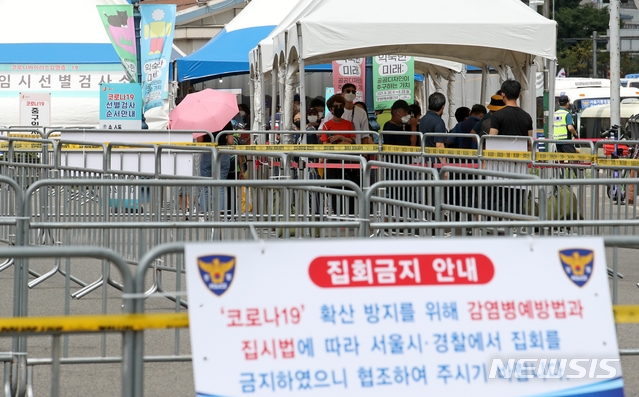 코로나19 신규 확진자가 1,930명으로 집계된 14일 오후 서울 중구 서울역 임시선별검사소에서 시민들이 검사를 받기 위해 줄을 서고 있다.