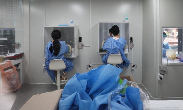 코로나19 신규 확진자가 1,805명으로 집계된 18일 오전 서울 서초구 고속버스터미널 임시선별검사소에서 의료진들이 검체채취를 하고 있다.