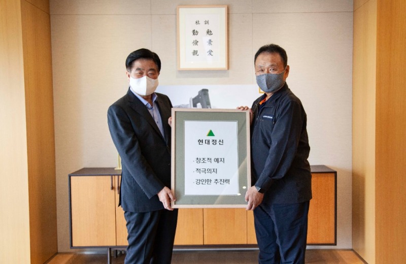 현대중공업지주 권오갑 회장이 두산인프라코어 손동연 사장에게 정주영 창업자의 경영 철학이 담긴 ‘현대정신’ 액자를 전달하고 있다. (사진 왼쪽부터 현대중공업지주 권오갑 회장, 두산인프라코어 손동연 사장)