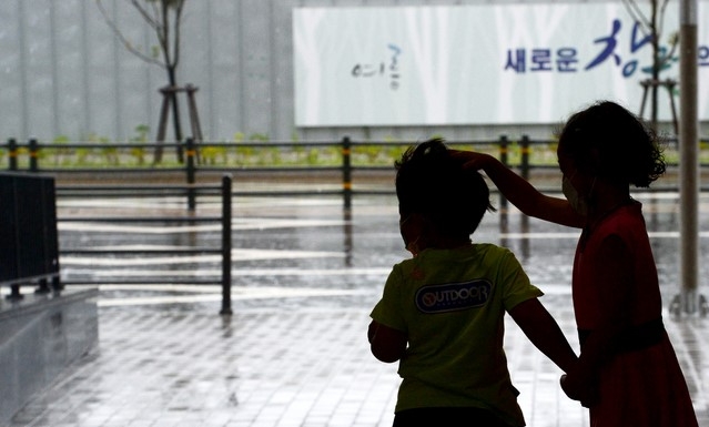 주말인 21일 오전 가을장마의 영향으로 전국에 많은 비가 내리고 있는 가운데 경남 창원시 중동로에서 어린이들이 비를 피하고 있다.