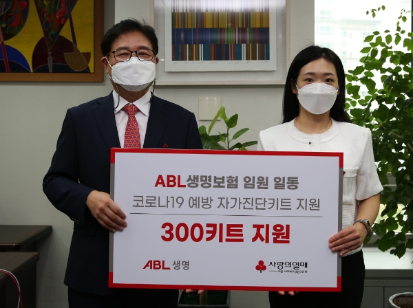 이상윤 ABL생명 인적자원실장(왼쪽)이 방성진 사랑의열매 사회공헌팀장에게 코로나19 예방 키트 300개를 전달하고 기념촬영을 하고 있다. 사진=ABL생명