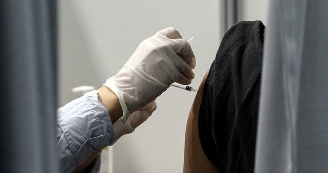 18~49세 대상 예방접종 시작을 하루 앞둔 25일 오전 서울 마포구민체육센터에 마련된 코로나19 예방접종센터에서 시민이 주사를 맞고 있다. 정부는 40대 이하 예방접종 시기를 보름여 앞당겨 추석연휴 전까지 전 국민 70%가 백신을 맞도록 할 계획이다.