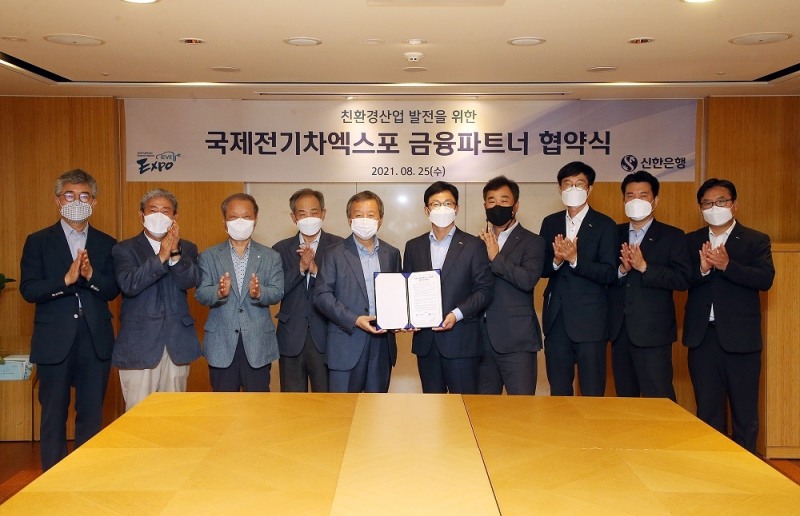 25일 서울시 중구에 위치한 대한상공회의소에서 진행된 업무협약식에서 신한은행 정지호 부행장(오른쪽에서 다섯번째)과 국제전기자동차엑스포 김대환 이사장(오른쪽에서 여섯번째)이 관계자들과 기념 촬영하는 모습. (사진=신한은행 제공)