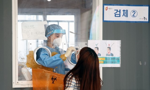 코로나19 일일 신규 확진자 수가 2,155명으로 집계된 25일 오후 서울 중구 서울역에 마련된 임시선별검사소에서 시민이 검사를 받고 있다.