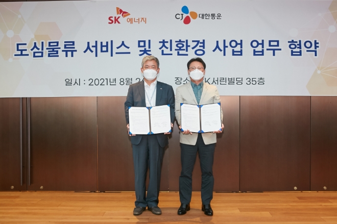 CJ대한통운 신영수 택배부문 대표(왼쪽부터)와 SK에너지 오종훈 P&M CIC대표가 기념촬영을 하고 있다./사진 제공 = 대한통운