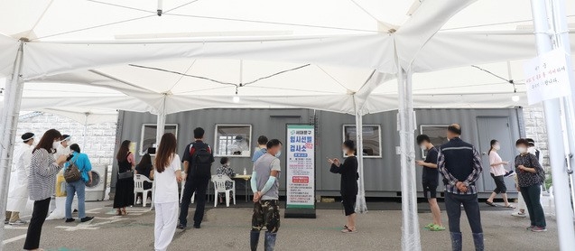 코로나19 일일 신규 확진자 수가 1882명으로 집계된 26일 오후 서울 서대문구 신촌역에 마련된 임시선별검사소에서 시민들이 검사를 기다리고 있다.