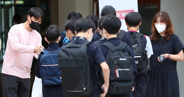 지난 17일 오전 2학기 개학을 맞은 세종시의 한 중학교에서 등교하는 학생들이 손소독을 하고 있다.