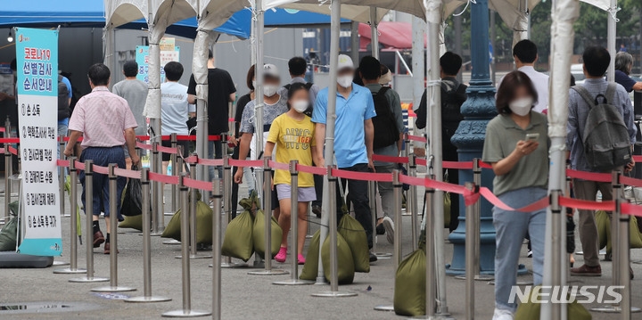 코로나19 신규 확진자가 1,372명으로 집계된 31일 오전 서울 중구 서울역 임시선별검사소에서 시민들이 검사를 받기 위해 대기하고 있다.