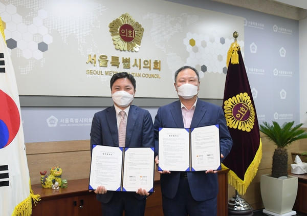 휴맥스모빌리티 오영현 공동대표(왼쪽)과 서울특별시의회 김인호 의장이 '친환경 모빌리티 확대를 위한 업무협약 체결하는 모습. 사진=휴맥스모빌리티