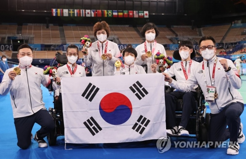 (도쿄=연합뉴스)4일 오후 일본 도쿄 아리아케 체조경기장에서 열린 2020 도쿄 패럴림픽 보치아 페어(BC3) 시상식에서 금메달을 목에 건 대한민국 최예진, 정호원, 김한수가 태극기를 들고 포즈를 취하고 있다.손으로 투구하기 어려운 사지마비 뇌성마비 장애인을 포함한 사지 마비 장애인이 출전하는 BC3 등급에서는 선수들이 홈통 등의 도구를 사용하며, 경기 파트너의 도움을 받는다.김한수와 최예진은 어머니가, 정호원은 이문영 코치가 경기 파트너로 나섰다.