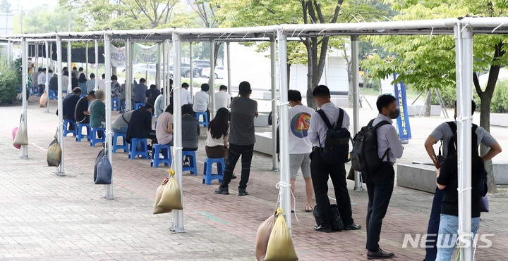 지난 10일 오전 서울 마포구 서강대역사 광장에 마련된 마포구 코로나19 임시선별검사소에서 시민들이 검사를 받기 위해 대기하고 있다.