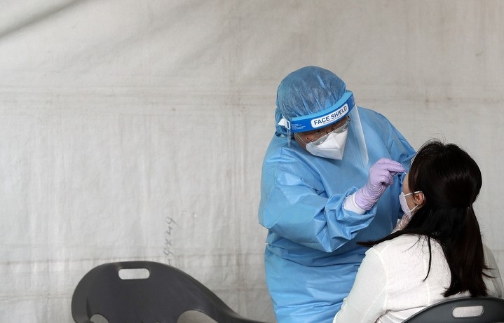 서울시가 가락시장 종사자에 대한 선제 검사 행정명령을 내린 다음날인 11일 오후 서울 송파구 가락시장에 설치된 찾아가는 선별진료소에서 의료진이 검체를 채취하고 있다.