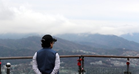 서울 용산구 N서울타워를 찾은 한 시민이 구름 낀 하늘을 바라보고 있다.