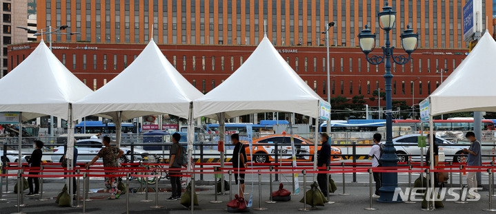 추석 연휴 셋째날인 20일 오전 서울 중구 서울역 광장 임시선별검사소에서 시민들이 코로나19 검사를 받기 위해 줄지어 서 있다.