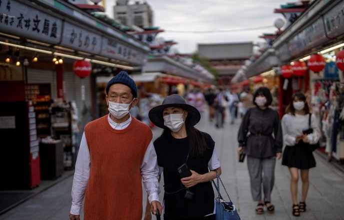 일본 도쿄 시내 쇼핑가에서 5일 코로나19 예방을 위해 마스크를 착용한 시민들이 가게 구경을 하면서 걸어가고 있다.