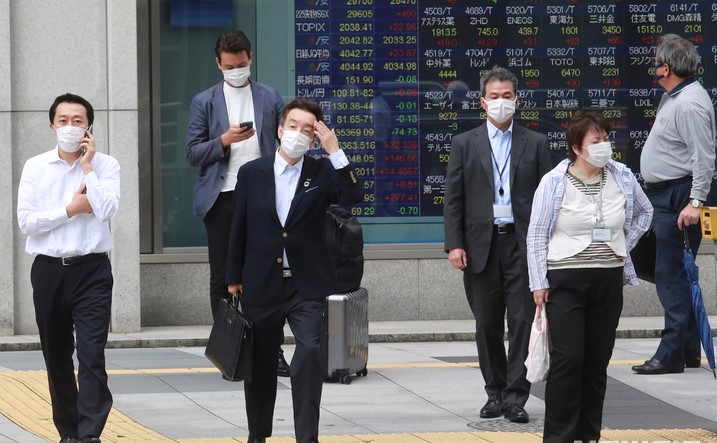 지난 6일 일본의 한 증권사 전광판 앞에서 마스크를 착용한 시민들이 길을 건너기 위해 기다리고 있다.