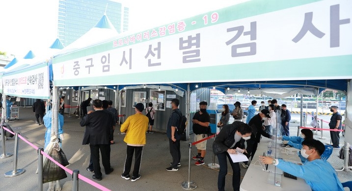 24일 오전 서울 중구 서울역광장 코로나19 임시선별검사소에서 시민들이 코로나19 검사를 받기 위해 줄지어 서 있다. 중앙방역대책본부에 따르면 이날 0시 기준 신규 코로나19 확진자는 2434명으로 역대 최다 신규 확진자를 기록했다.