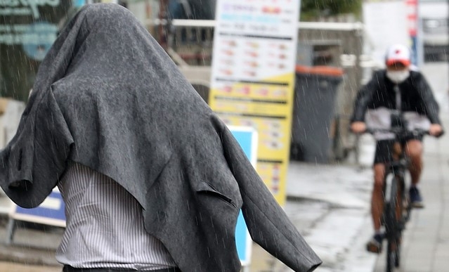 가을비가 내린 16일 오후 인천시 남동구 인천시청 앞에서 미처 우산을 준비하지 못한 시민이 양복 상의로 머리를 가리고 걸어가고 있다. 