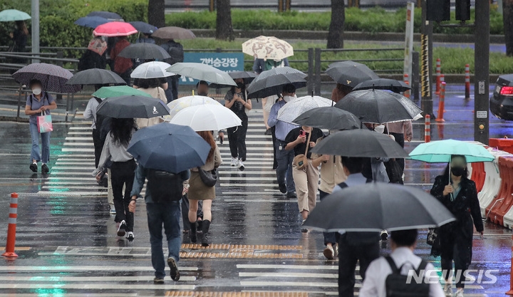 가을비가 내리는 지난달 29일 오전 서울 중구 서울역 인근에서 시민들이 우산을 쓰고 횡단보도를 건너고 있다.