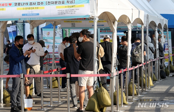 지난 3일 오전 서울 중구 서울역광장에 마련된 선별진료소에서 시민들이 검사를 받기 위해 대기하고 있다.