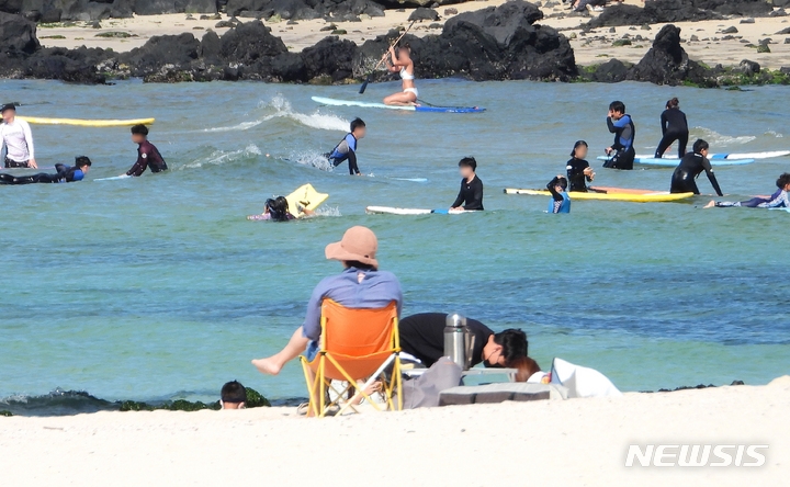 낮기온이 30도를 웃도는 등 한여름 날씨를 보인 4일 오후 제주시 애월읍 곽지해수욕장을 찾은 레저객들이 물놀이를 하며 즐거운 시간을 보내고 있다. 기상청에 따르면 이날 제주시 낮 최고기온은 30.1도를 기록했다.