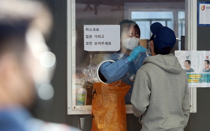 질병관리청 중앙방역대책본부에 따르면 0시 기준 코로나19 누적 확진자가 전날보다 1297명 증가한 33만2816명을 기록한 11일 서울역 임시선별검사소를 찾은 시민이 검사를 하고 있다.