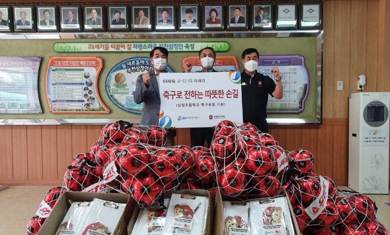 김용진 GS파워 지역협력팀 처장(가운데)과 부천 FC 김성남 단장이 (오른쪽)와 이 부천초등학교에 축구사인볼과 기념품을 전달하고 있다.