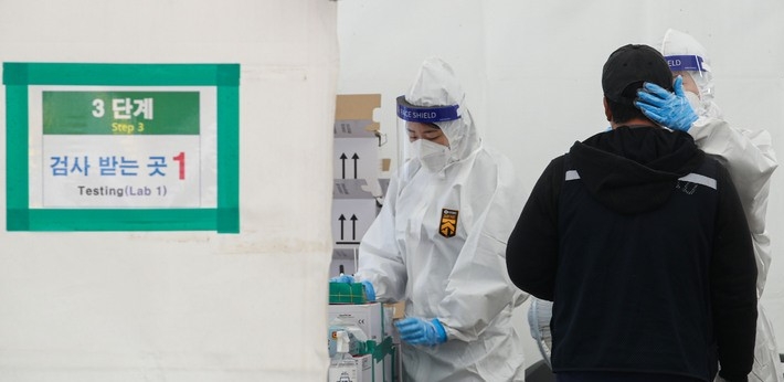 지난 18일 오전 서울 마포구 서강대역사 광장 임시선별검사소에서 의료진이 검체검사를 하고 있다.